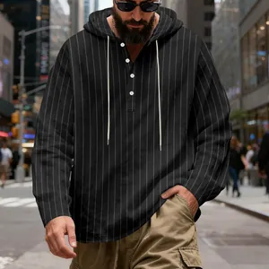 Detail of men's black pinstripe linen hoodie with white buttons and adjustable hood