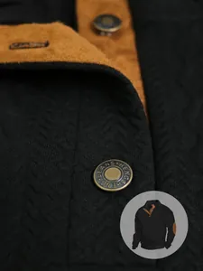 Primo piano del tessuto jacquard nero e dei bottoni in bronzo della maglia Henley.