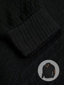 Primo piano della trama in maglia jacquard nera e del polsino a coste di una maglia Henley da uomo
