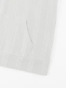 Close-up detail of white cable-knit jacquard texture and kangaroo pocket on men's hoodie