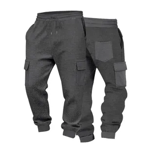Vista dettagliata dei pantaloni cargo grigio scuro in maglia a nido d'ape, fronte e retro