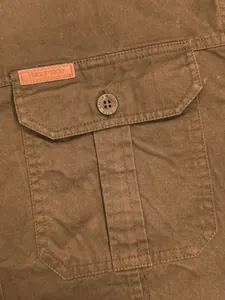 Gros plan détaillé d'une poche de chemise de travail marron pour homme avec étiquette