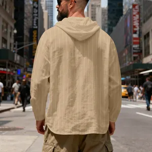 Detailed back view of men's tan striped linen hooded sweatshirt in urban city street