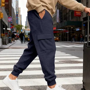 Dettaglio dei pantaloni cargo in maglia a nido d'ape blu navy con tasche funzionali.