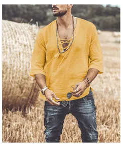 Detail of yellow cotton-linen V-neck lace-up shirt worn by a male model outdoors
