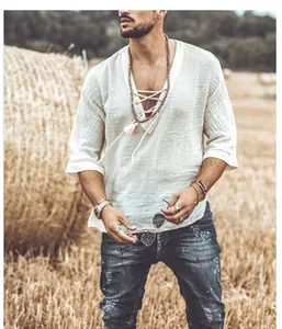 Close-up detail of a white men's V-neck lace-up linen shirt in a rustic field setting