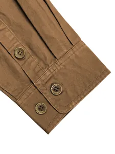 Gros plan du poignet d'une chemise de travail marron pour hommes avec boutons.
