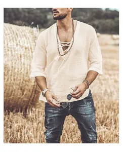 Detailed look of men's V-neck linen shirt with lace-up design in a rustic field setting