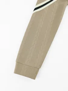 Close-up of heavyweight jacquard sleeve texture with striped detail on khaki hoodie.