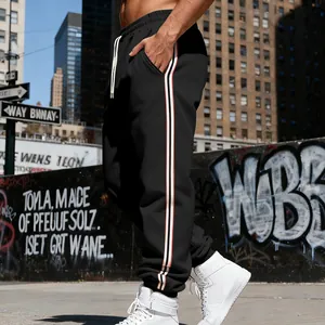 Vista laterale di pantaloni sportivi neri da uomo con strisce verticali in stile urbano.
