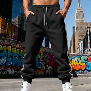 Dettaglio dei pantaloni sportivi neri da uomo con strisce laterali e coulisse in vita