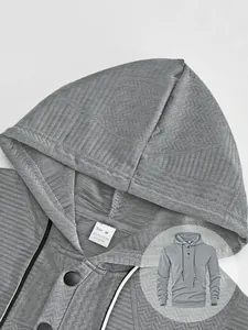 Vue détaillée d'un sweat à capuche gris pour homme avec texture jacquard et étiquette