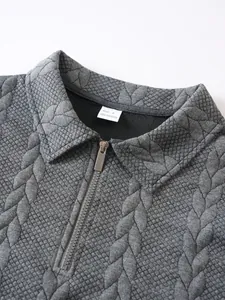 Primo piano della trama jacquard grigia e del colletto con mezza zip sulla felpa pesante da uomo.