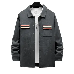 Gros plan d'une veste de travail grise pour homme avec détails de poches rayées.