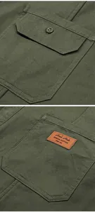 Detail view of army green cotton shirt showing double pockets and leather patch