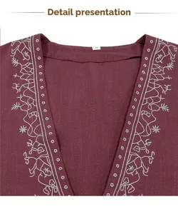 Close-up of intricate white embroidery on a burgundy men's V-neck shirt collar