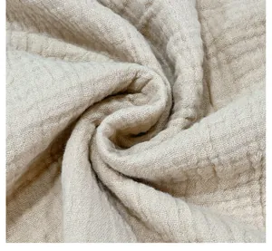 Close-up detail of beige pure cotton muslin fabric texture for men's casual summer shirt