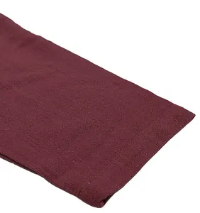 Close-up of burgundy linen fabric showing breathable texture and weave detail.