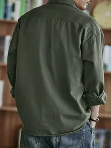 Back view of a retro loose casual olive green workwear shirt for men in library