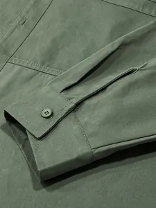 Detailed view of cuff and button on men's olive green vintage utility long sleeve shirt