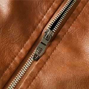 Close-up detail of a metal zipper on a brown textured leather motorcycle jacket for men.