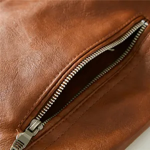 Close-up detail of a premium brown leather jacket featuring a durable silver metal zipper