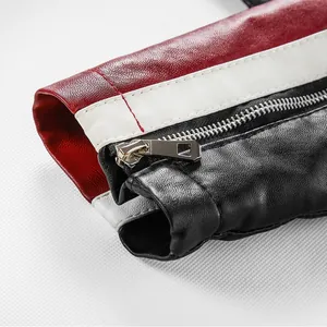 Detail of a color-block leather motorcycle jacket with zipper sleeve and red accents.