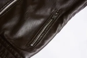 Close-up of dark brown PU leather jacket showing detailed texture and silver zipper pocket.