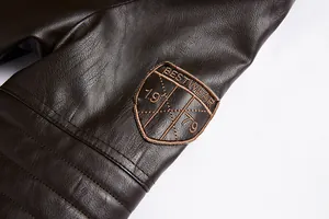 High-quality close-up detail of brown PU leather jacket sleeve with vintage embroidered patch.