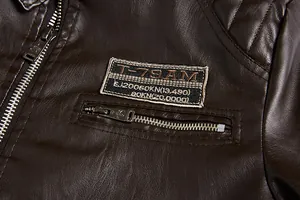 Close-up detail of a dark brown PU leather jacket with an embroidered patch and zip pocket