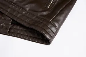 Close-up detail of the stitching and hem texture on a dark brown PU leather jacket