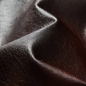 Makroaufnahme der dunkelbraunen PU-Ledertextur mit hochwertigem Narbenmuster für Jacken.