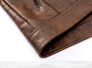 Detailed close-up showing the hem and premium leather texture of the brown jacket