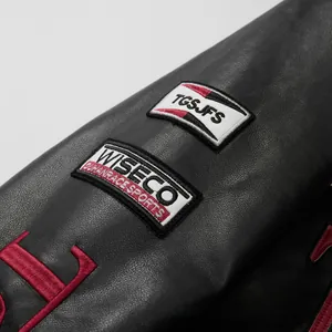 Close-up detail of a black racing leather jacket showing high-quality embroidery patches