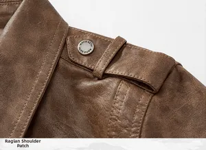 Macro detail of raglan sleeve seam and engraved logo button on a brown leather jacket