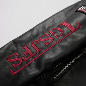 Close-up of red embroidered letters on black racing motorcycle leather jacket texture