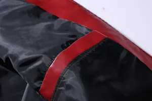 Close-up showing the red and black faux leather texture and lining of a biker jacket