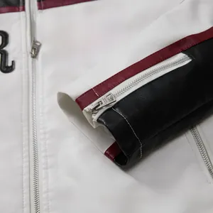 Detailed macro view of the sleeve cuff and zipper on a color-blocked racing jacket