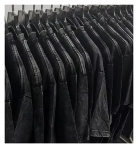 Close-up of heavy acid-washed vintage black t-shirts hanging on a clothing rack.