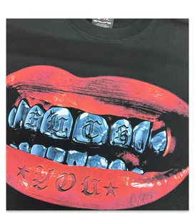 Close-up detail of the red lip and grillz graphic on a black heavy cotton t-shirt.