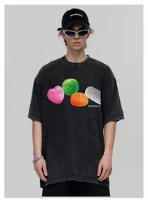 Detail of washed black oversized streetwear t-shirt with heart and pill graphic print.