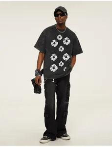 Full body shot of a man wearing a dark grey acid wash street style printed t-shirt.