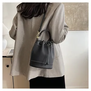 Sac seau noir élégant avec cordon de serrage et surpiqûres blanches sur un modèle