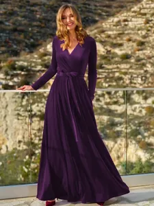 Elegante abito lungo in velluto viola con scollo a V e maniche lunghe in ambiente aperto