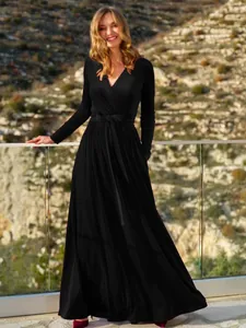 Vista intera dell'elegante abito lungo in velluto nero con scollo a V e fiocco in vita