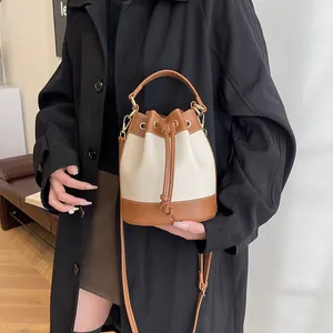 Elegant vintage color-block drawstring bucket bag with gold hardware and shoulder strap
