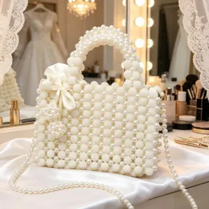 Borsa a mano in perle bianche fatta a mano con elegante fiocco in seta e tracolla lunga