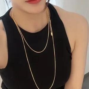 Detail of 18K gold plated stainless steel square snake bone long chain on model.