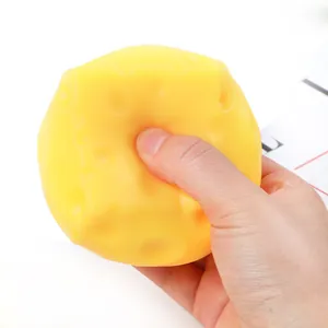Detailed shot of a hand squeezing a yellow slow rebound cheese squishy stress toy