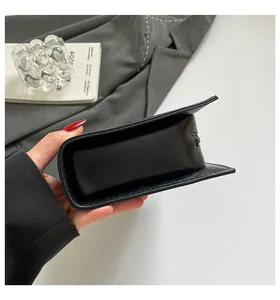 Detail view showing the side thickness and sleek finish of the black crossbody bag.